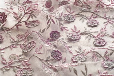 Doku, arka plan, desen. Pembe dantel çiçek üzerinde beyaz bir arka plan ile dekore edilmiştir. Arka planını çiçekler ile dekore edilmiş pembe dantel kumaş