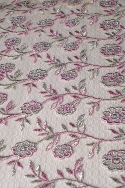 Doku, arka plan, desen. Pembe dantel çiçek üzerinde beyaz bir arka plan ile dekore edilmiştir. Arka planını çiçekler ile dekore edilmiş pembe dantel kumaş