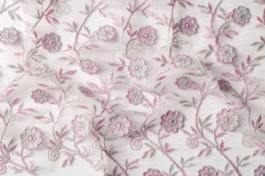 Doku, arka plan, desen. Pembe dantel çiçek üzerinde beyaz bir arka plan ile dekore edilmiştir. Arka planını çiçekler ile dekore edilmiş pembe dantel kumaş