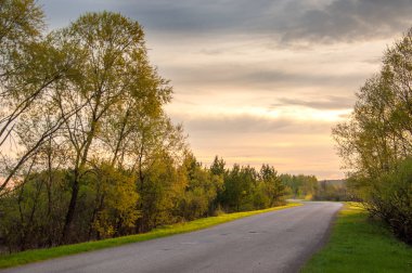 Bahar peyzaj, gündoğumu gündoğumu. Köy yolunda, bir yol ile kırsal manzara.