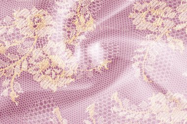 Resmi doku arka planı, dekoratif altın dantel desenli. Altın vintage dantelli arka plan. Altın dantel pembe bir arka plan üzerinde. Spandex, makro. Dantelli dekoratif çiçek desenli.