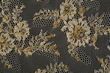 Resmi doku arka planı, dekoratif altın dantel desenli. Altın vintage dantelli arka plan. Siyah bir zemin üzerine altın dantel. Spandex, makro. Dantelli dekoratif çiçek desenli.