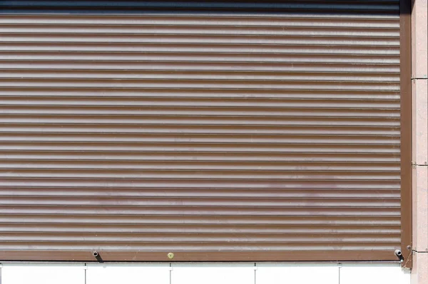 Summer landscape, city walls, metal shutters. Front view of black metal windows. Abstract dark brown metallic background