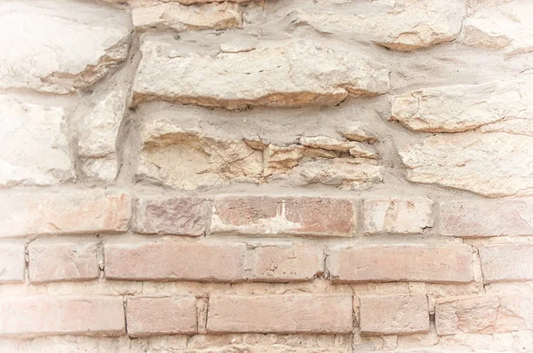 Texture, background, pattern. An old cement stone wall as vintage cracked, worn and worn out creative poster design. Cracks, scrapes, peeling old paint and plaster on the background of old cement wall