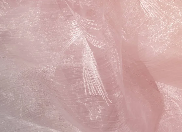 Texture, background, pattern. Tulle of pastel pink tones. Abstract background of pink fabric. Soft texture of the fabric, pink pastel tone. Shabby chic style. Crumpled tulle as a background.