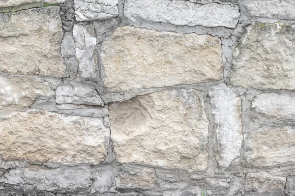 Doku, arka plan, desen. Eski granit taşlar. Eski bir taş duvar. Taştan bir duvar dokusu. Bir eski gri taş ve kum taşı doku kökenli tuğla duvar.