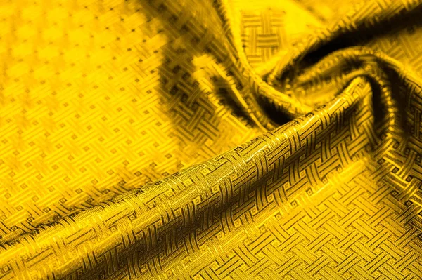Background texture, pattern. Yellow, mustard silk fabric with a