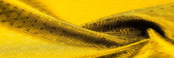 Background texture, pattern. Yellow, mustard silk fabric with a