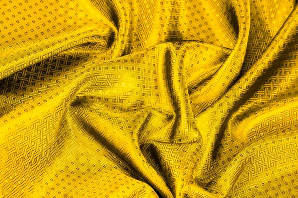 Background texture, pattern. Yellow, mustard silk fabric with a