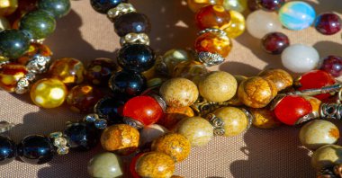 Doku, arka plan, desen. Halk sanatı. Çok renkli taş ve camlardan boncuklar.