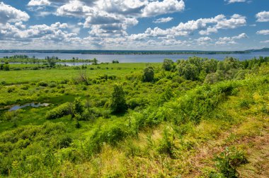 Yaz fotoğrafçılığı, su çayırları, nehir taşkın ovaları, dağdan çekilmiş fotoğraflar. Nehrin kenarında yemyeşil çimenler, çam, huş ağacı, fındık ağacı yetişir. sıcak yaz günleri