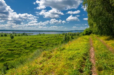 Yaz fotoğrafçılığı, su çayırları, nehir taşkın ovaları, dağdan çekilmiş fotoğraflar. Nehrin kenarında yemyeşil çimenler, çam, huş ağacı, fındık ağacı yetişir. sıcak yaz günleri