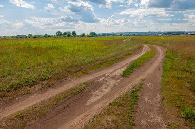 Yaz manzarası, gök gürültülü bulutlar, mavi gökyüzü, sel basmış çayır tarlaları, yaz renklerinin kokusu ve çeşitli kır çiçekleri.