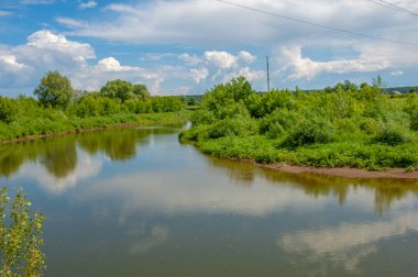 Yaz manzarası, gök gürültülü bulutlar, mavi gökyüzü, sel basmış çayır tarlaları, yaz renklerinin kokusu ve çeşitli kır çiçekleri.
