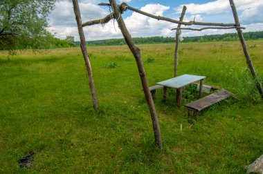 Yaz manzarası, gök gürültülü bulutlar, mavi gökyüzü, sel basmış çayır tarlaları, yaz renklerinin kokusu ve çeşitli kır çiçekleri.