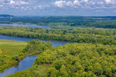 Yaz manzarası, bir kanaldan denize, bir göle ya da başka bir dereye akan büyük bir doğal su akıntısı. Sel, nulla, sıvı, ford. Yüksek tepe kıyıları