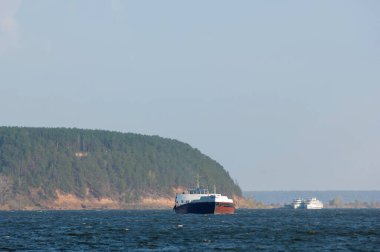Sonbahar manzarası, koyu mavi su, son sıcak günler, nehir, ağaçlar, rüzgarlı hava, sarı-kırmızı sonbahar yaprakları.