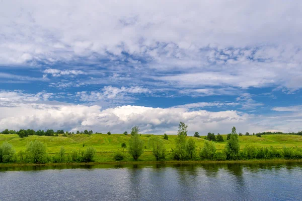 Yaz fotoğrafı, güçlü gök gürültülü bulutlar, mavi gökyüzü, karanlık keskin su, Kama Nehri boyunca turist yürüyüşü.
