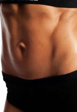 Beyaz arka planda bir modelin stüdyo fotoğrafı, sağlıklı yaşam tarzı, güzel karın kasları, kabartmalı karın kasları, hızlı bir şekilde evde bir kıza karın presi pompalaması.