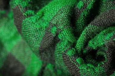 Doku, arka plan, desen. Bir insanın boynuna takılacak yün bir eşarp. Atkıda yeşil siyah renk.