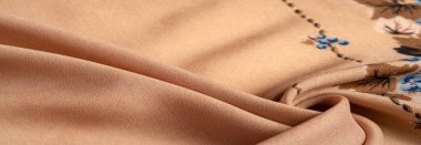 Doku, arka plan, şekil, Crepe de Chin. Bej rengi, mavi çiçekler. Bu bir ipek grubu, pürüzle karakterize edilmiş, aynı zamanda hafif kırışık..