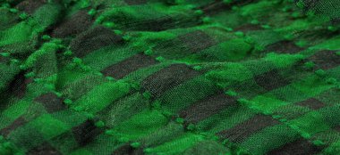 Doku, arka plan, desen. Bir insanın boynuna takılacak yün bir eşarp. Atkıda yeşil siyah renk.