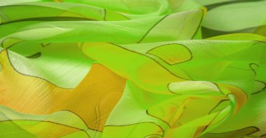 Arka plan dokusu bir organza deseni. İnce, şeffaf kumaştan bir kumaş. İnce, yapışkan ipekten bir peçe gibi. yeşil beyaz sarı gri geometrik renkler