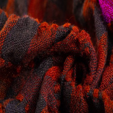 Doku, arka plan, desen. Bir insanın boynuna takılacak yün bir eşarp. Atkıda kahverengi kırmızı siyah renk.