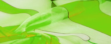 Arka plan dokusu bir organza deseni. İnce, şeffaf kumaştan bir kumaş. İnce, yapışkan ipekten bir peçe gibi. yeşil beyaz sarı gri geometrik renkler