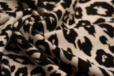 Doku, arkaplan, desen, kadın yün şalı, siyah ve bej, Afrika motifleri, yün ve modülden yapılmış, kenarları kıvrımlı bir yılan şeklinde..