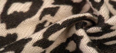 Doku, arkaplan, desen, kadın yün şalı, siyah ve bej, Afrika motifleri, yün ve modülden yapılmış, kenarları kıvrımlı bir yılan şeklinde..