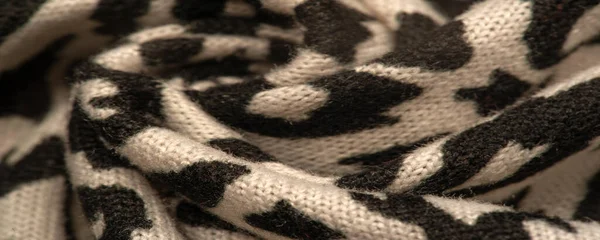 Texture, background, pattern, women\'s woolen shawl, black and beige, African motifs, shawl made of wool and modal with print in the form of a snake with a hem.