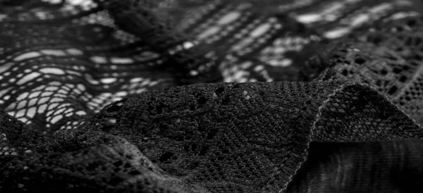 Background, texture, pattern, black lace fabric, thin open fabric, usually made of cotton or silk, made using loops, twisting or knitting threads in patterns