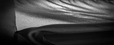 Arkaplan dokusu koyu siyah şifon ipeği yumuşak şeffaf bir kumaştır ve pürüzlüdür (matte, creped) çünkü bükülmüş iplik kullanımı.
