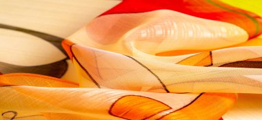 Arka plan dokusu bir organza deseni. İnce, şeffaf kumaştan bir kumaş. İnce, yapışkan ipekten bir peçe gibi. yeşil kırmızı kırmızı geometrik renkler