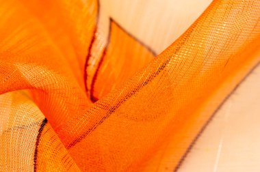 Arka plan dokusu bir organza deseni. İnce, şeffaf kumaştan bir kumaş. İnce, yapışkan ipekten bir peçe gibi. yeşil kırmızı kırmızı geometrik renkler