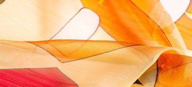 Arka plan dokusu bir organza deseni. İnce, şeffaf kumaştan bir kumaş. İnce, yapışkan ipekten bir peçe gibi. yeşil kırmızı kırmızı geometrik renkler