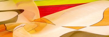 Arka plan dokusu bir organza deseni. İnce, şeffaf kumaştan bir kumaş. İnce, yapışkan ipekten bir peçe gibi. yeşil kırmızı kırmızı geometrik renkler