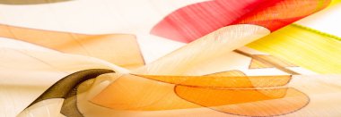 Arka plan dokusu bir organza deseni. İnce, şeffaf kumaştan bir kumaş. İnce, yapışkan ipekten bir peçe gibi. yeşil kırmızı kırmızı geometrik renkler