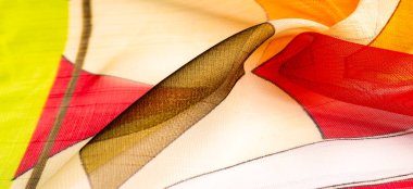Arka plan dokusu bir organza deseni. İnce, şeffaf kumaştan bir kumaş. İnce, yapışkan ipekten bir peçe gibi. yeşil kırmızı kırmızı geometrik renkler