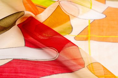 Arka plan dokusu bir organza deseni. İnce, şeffaf kumaştan bir kumaş. İnce, yapışkan ipekten bir peçe gibi. yeşil kırmızı kırmızı geometrik renkler