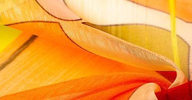 Arka plan dokusu bir organza deseni. İnce, şeffaf kumaştan bir kumaş. İnce, yapışkan ipekten bir peçe gibi. yeşil kırmızı kırmızı geometrik renkler