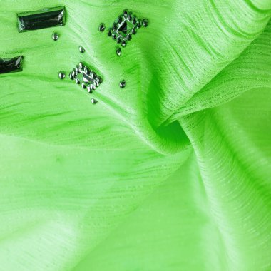 Arkaplan tasarımı dokusu, ipek desen, yeşil kumaş ve dekoratif işlemeli taşlar.