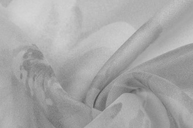 Doku, arka plan, gri çiçekli beyaz ipek süs. Kumaşın bir Jacquard dokuması var. Bu kumaş sayesinde yumuşak bir şekilde parıldayan saten bölümler elde etti.