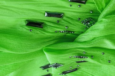 Arkaplan tasarımı dokusu, ipek desen, yeşil kumaş ve dekoratif işlemeli taşlar.