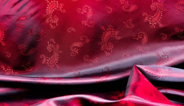 Doku, kumaş, desenli kırmızı ipek. Bu güzel baskılı ipek Charmeuse 'un deseni kalın desenli. Vatansever görünümde kırmızı renkler var, kumaşın kaygan bir eli var.