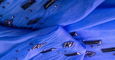 Arkaplan tasarımı dokusu, ipek desen, mavi kumaş ve dekoratif işlemeli taşlar.