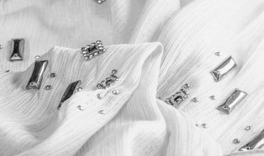 Arkaplan tasarımı dokusu, ipek desen, dekoratif taşlarla kaplı beyaz kumaş.