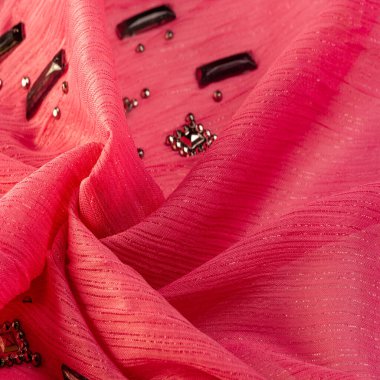 Arkaplan tasarımı dokusu, ipek desen, pembe kumaş ve dekoratif işlemeli taşlar.