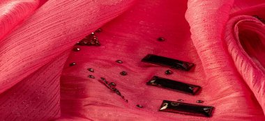 Arkaplan tasarımı dokusu, ipek desen, pembe kumaş ve dekoratif işlemeli taşlar.